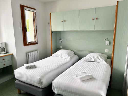 Duas camas individuais num quarto com um espelho. em Cerise Nantes La Beaujoire em Nantes