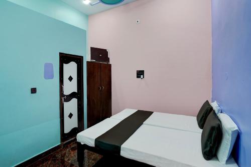 1 dormitorio con cama y pared azul en OYO Balaji Premium CO- Living, en Kutāna