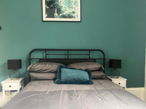 um quarto azul com uma cama com duas mesas de cabeceira em Myrtle Villas em Hull