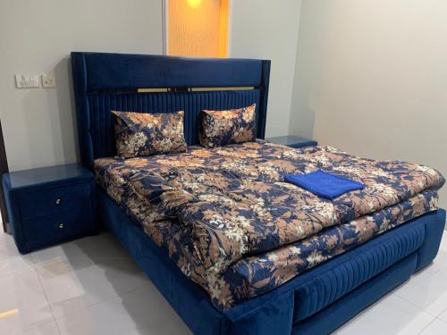um quarto com uma cama azul com uma moldura azul em Park View Residency 1 em Rawalpindi