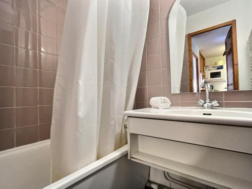 een badkamer met een wastafel en een douchegordijn bij Appartement Val-d'Isère, 2 pièces, 4 personnes - FR-1-411-153 in Val dʼIsère