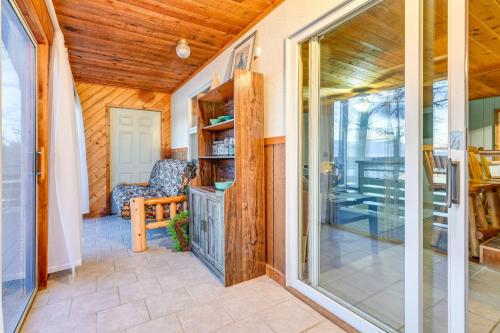 a room with a sliding glass door leading to a patio at Lake Home with Dock and Fire Pit Steps to Sandy Beach in Lake