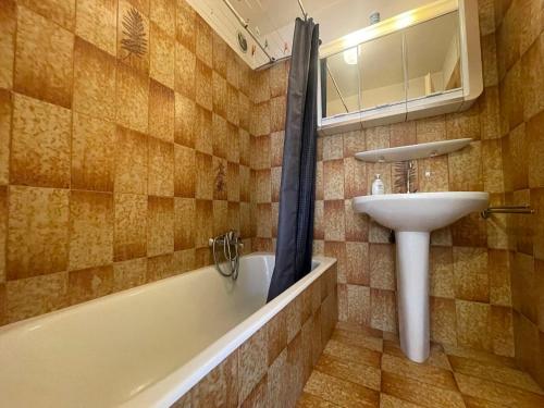 une salle de bain avec un lavabo et une baignoire et un lavabo dans l'établissement Appartement T2 duplex au coeur de Samoëns, balcon, WIFI, animaux admis - FR-1-624-1, à Samoëns