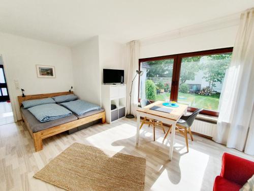 a bedroom with a bed and a table with a desk at Ferienwohnung Gartenblick - Idylle am Travetal in Bad Oldesloe