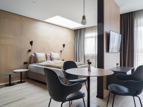 una camera d'albergo con letto, tavolo e sedie di Hotel Lotus a Reykjavik