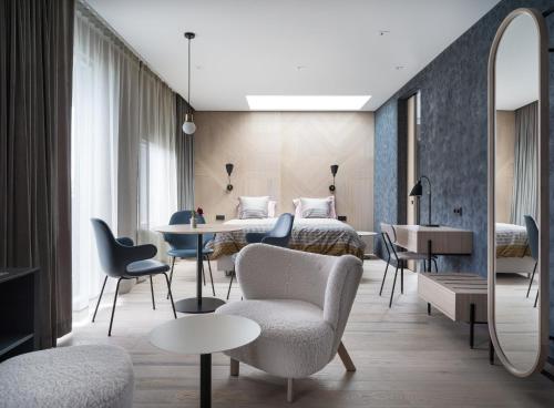 een hotelkamer met 2 bedden en een tafel en stoelen bij Hotel Lotus in Reykjavík