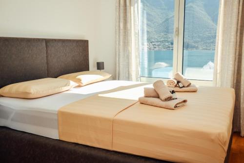 Un dormitorio con dos camas con toallas encima. en Sea view apartment for 4, en Kotor