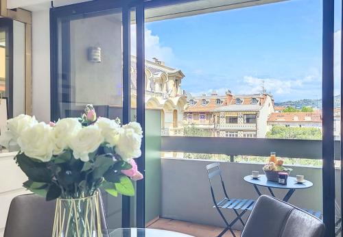 un vase de fleurs posé sur une table sur un balcon dans l'établissement Nestor&Jeeves - POP ART - central - balcony, à Nice