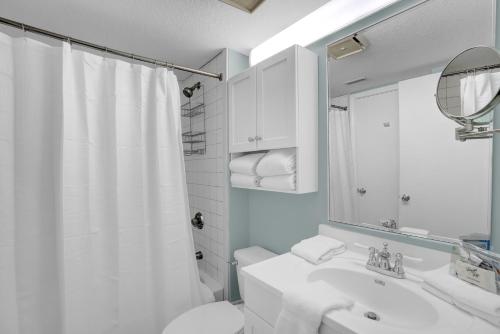 y baño con lavabo, aseo y espejo. en Harbour Place 109, en Gulf Shores