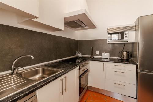 a kitchen with white cabinets and a sink at Lagos Appartement Resort in Lagos