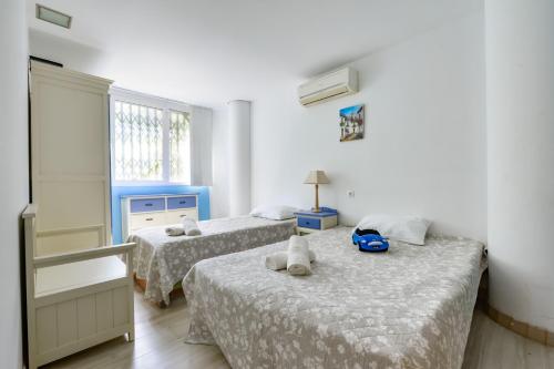 Un dormitorio con dos camas y una ventana. en Enorme apartamiento en CALA ALTA de Villajoyosa, en Cala de Finestrat