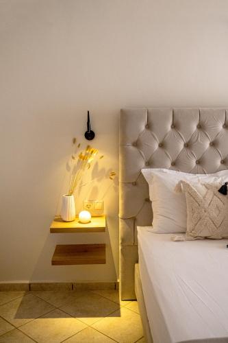 a bed with a night stand next to a side table at Aegean Majesty in Azolimnos Syros