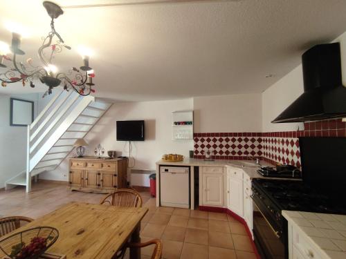une cuisine avec une table et une salle à manger dans l'établissement Villa 30, La Palmeraie au village naturiste, au Cap d'Agde