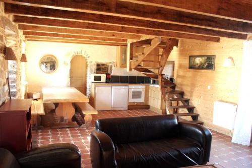 un salon avec un canapé et un escalier en colimaçon dans l'établissement La Colline Aux Écureuils, à Irvillac