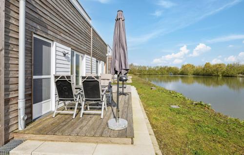 StickにあるAmazing Home In Tossens With Kitchenの家の横に傘と椅子が置かれたパティオ