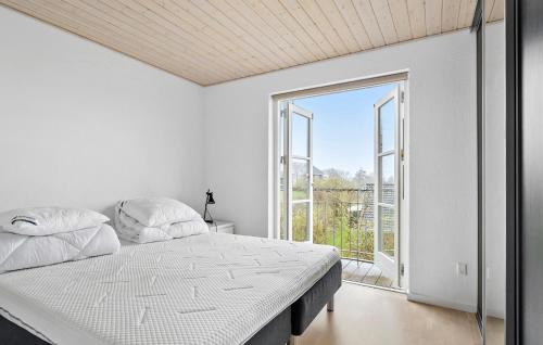 a white bedroom with a bed and a large window at 3 Bedroom Nice Home In Aabenraa in Aabenraa