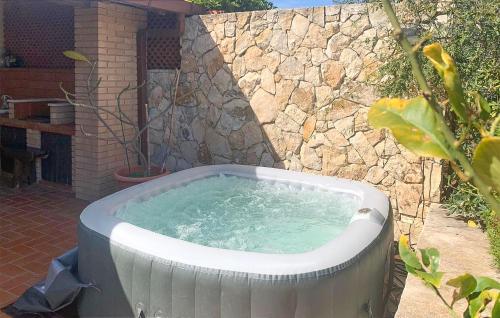 a hot tub in front of a stone wall at Amazing Home In Marina Di Modica in Marina di Modica