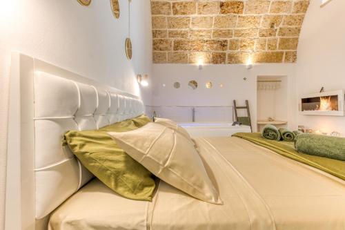 プレシッチェにあるBilocale con vasca idromassaggioのベッドルーム(大きな白いベッド、金の枕付)
