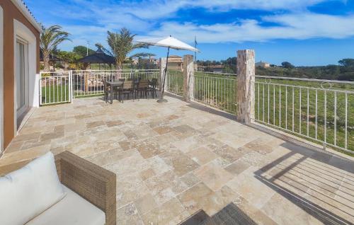 a patio with a table and an umbrella at Lovely Home In Villespassans With Wifi in Villespassans