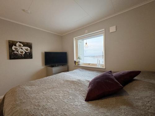 um quarto com uma cama grande e uma janela em Fantastic villa with a sea view in Torslanda em Torslanda