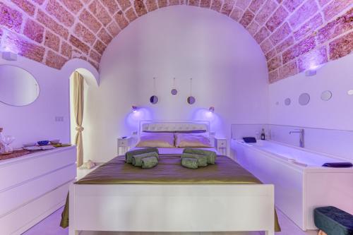 プレシッチェにあるBilocale con vasca idromassaggioの白いベッドルーム(ベッド1台、バスタブ付)