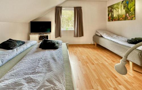 - un salon avec 2 lits et une télévision à écran plat dans l'établissement Stunning Apartment In Uggdal With Harbor View, à Uggdal