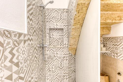 a shower in a bathroom with a tile wall at Bilocale con vasca idromassaggio in Presicce