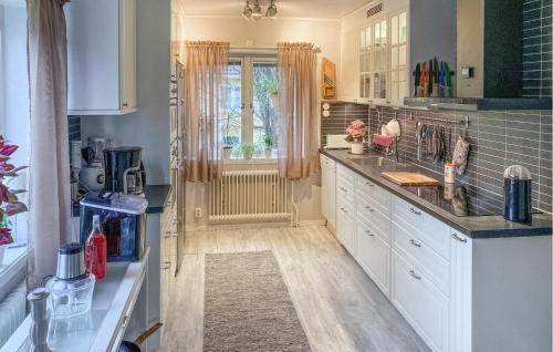 een keuken met witte kasten en een raam bij Amazing Home In Vstervik With Heated Swimming Pool in Västervik
