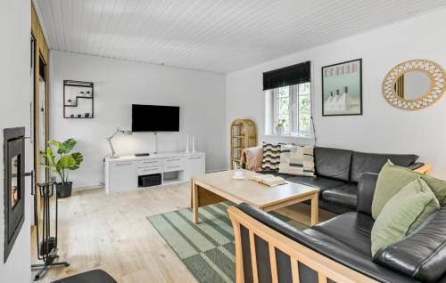 uma sala de estar com um sofá e uma mesa em Ronaldo em Strandby Gårde