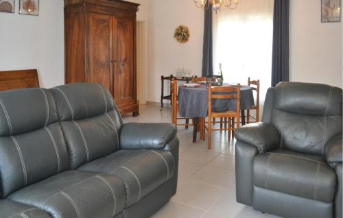 a living room with two leather chairs and a table at Gorgeous Home In Marcillac-La-Croisille in Marcillac-la-Croisille
