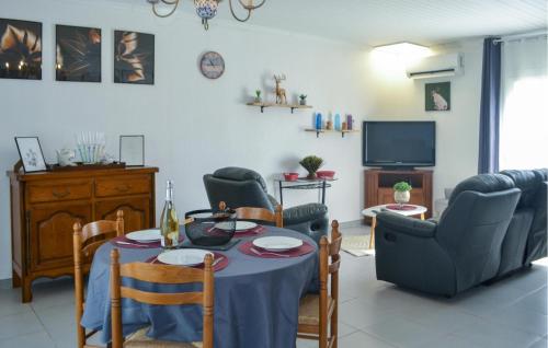 un salon avec une table, des chaises et une télévision dans l'établissement Gorgeous Home In Marcillac-La-Croisille, à Marcillac-la-Croisille