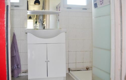 bagno bianco con lavandino e specchio di Nice Home In Marcillac-la-croisille With Wi-fi a Marcillac-la-Croisille