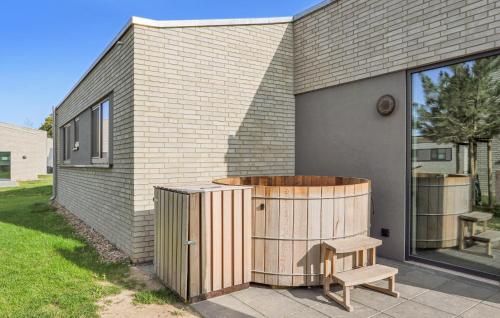 a wooden tub sitting next to a brick building at Lovely Home In Lembruchdümmer See in Lembruch