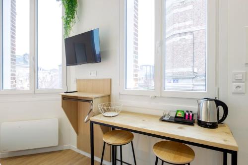 une cuisine avec un comptoir et des tabourets dans une pièce dans l'établissement Appartement 2 proche de la gare et centre ville, à Amiens