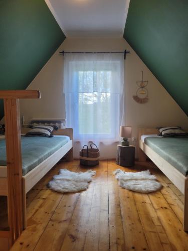 a attic room with two beds and a window at HENRYKOWO in Stronie Śląskie