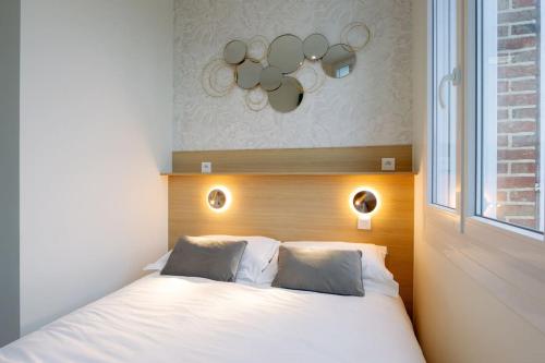 une chambre avec un lit blanc avec une fenêtre dans l'établissement Appartement 2 proche de la gare et centre ville, à Amiens
