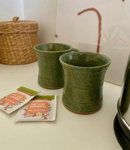 trois vases verts posés sur un comptoir à côté de dans l'établissement Charmante chambre dans une maison de campagne, à Saint-Étienne-de-Fontbellon