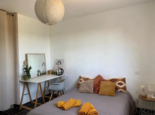 une chambre avec un lit, un bureau et un miroir dans l'établissement Charmante chambre dans une maison de campagne, à Saint-Étienne-de-Fontbellon