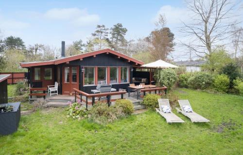 a small cabin with a picnic table and benches at Beautiful Home In Vejby With Kitchen in Vejby