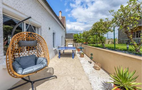 une chaise en osier assise au-dessus d'une terrasse dans l'établissement Amazing Apartment In Amblainville, à Amblainville