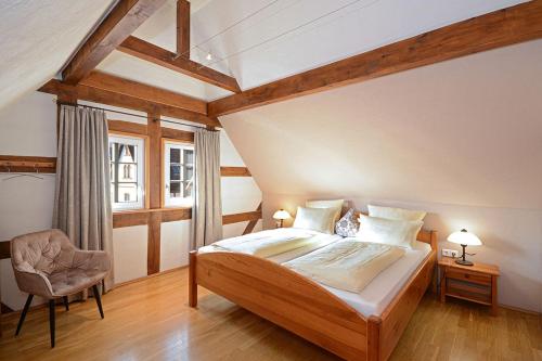 ein Schlafzimmer mit einem Bett, einem Stuhl und einem Fenster in der Unterkunft Landhotel Hauer in Pleisweiler-Oberhofen