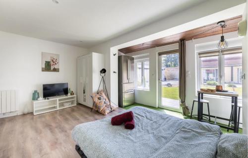 Nice Apartment In Amblainville With Kitchenette في Amblainville: غرفة نوم فيها سرير وتلفزيون