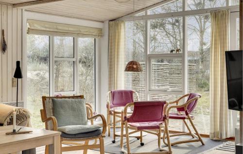 a living room with chairs and a tv and windows at Beautiful Home In Blåvand With Wifi in Blåvand