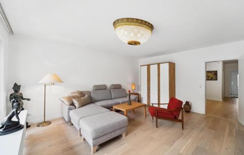 een woonkamer met een bank en een rode stoel bij 1 Bedroom Gorgeous Home In Bad Zwischenahn in Bad Zwischenahn