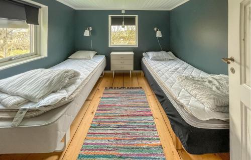 duas camas num quarto com um tapete em 3 Bedroom Lovely Home In Varberg em Varberg