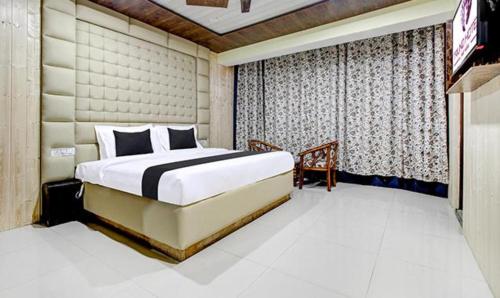 a bedroom with a large bed and a television at FabHotel Prime Grand Ali in Srinagar