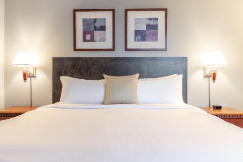 a large white bed with two lamps on two tables at Hôtel Saint-Laurent Montréal in Montréal