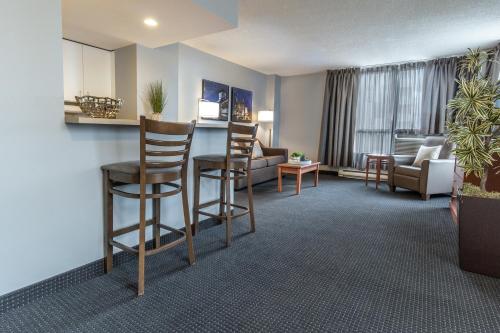 a living room with chairs and a bar in a hotel room at Hôtel Saint-Laurent Montréal in Montréal