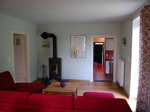 a living room with a red couch and a fireplace at Häuschen in Utarp in Utarp
