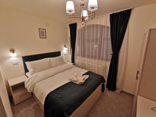 a bedroom with a large bed and a window at Cerbul Chalét Accommodation & Wellness in Râşnov